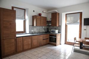 cocina con armarios de madera, mesa y ventana en Maison Bordon - Le Petit Château, en Nus