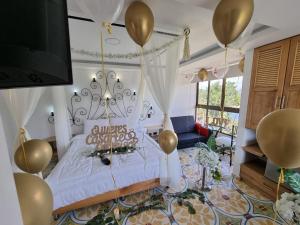 una camera da letto con un letto con palloncini dorati di Hotel Bahia Del Faro a Guatapé