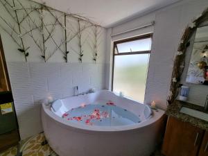 un bagno con ampia vasca e finestra di Hotel Bahia Del Faro a Guatapé