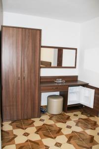 einen Schreibtisch mit einem Schrank und einem Spiegel in einem Zimmer in der Unterkunft Hotel Corina in Borsa