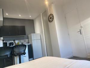 a kitchen with a refrigerator and a clock on a wall at Studio in Brignoles