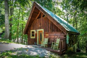Cabaña con 2 sillas y porche en el bosque en Alone at Last - Sage Vacations, en Pigeon Forge