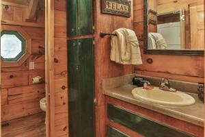 baño con lavabo y espejo en una cabina en Alone at Last - Sage Vacations, en Pigeon Forge