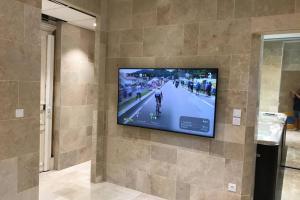 a flat screen tv hanging on a wall at NID D AMOUR F1 40m2 calme RDC possibilité jacuzzi hammam in Chamalières