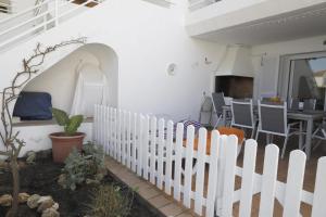 una recinzione bianca in un cortile con tavolo e sedie di Villa Pilar a Es Mercadal