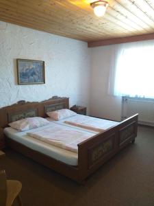 a bedroom with a large bed in a room at Mesnerwirt in Neukirchen am Teisenberg