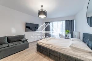 sypialnia z dużym łóżkiem i kanapą w obiekcie Apart Park 302 RUBUS w Świnoujściu