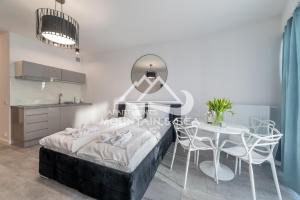 sypialnia z łóżkiem, stołem i krzesłami w obiekcie Apart Park 302 RUBUS w Świnoujściu +31 zdjęć