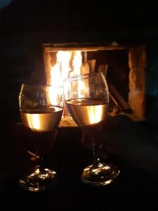 dos copas de vino frente a una chimenea en Finca Formentera, este tu pequeño paraíso, en Dosquebradas