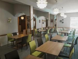 a dining room with tables and chairs and chandeliers at Hotel Orion in Vodice