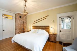 a bedroom with a white bed and a brick wall at The Copeland in Revelstoke
