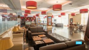 a lobby of a restaurant with couches and tables at Vila Galé Salvador in Salvador