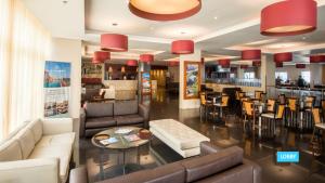 a lobby with couches and a bar in a restaurant at Vila Galé Salvador in Salvador