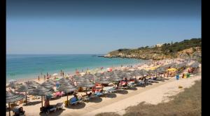 een strand met veel parasols en mensen op het strand bij Happy House-fantastic holiday with all amenities in Albufeira