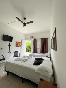 a bedroom with two beds and a ceiling fan at Pousada Vila Real Juquehy in Juquei