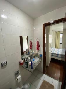 a bathroom with a sink and a mirror at Recreio, a praia mais charmosa do RJ! in Rio de Janeiro