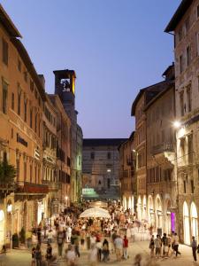 una folla di persone che camminano per una strada di notte di VANNUCCI 71 APT a Perugia