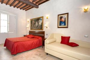 a hotel room with two beds and a couch at Relais Dei Mercanti B&B And Suites in Pisa