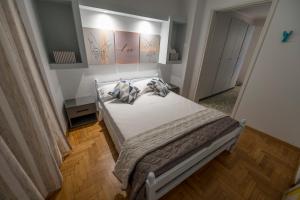 a bedroom with a white bed with pillows on it at Kliton Comfort Portaremounta Apartment in Corfu