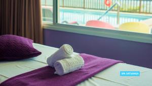a towel on top of a bed with a pool at Vila Galé Salvador in Salvador