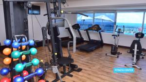 a gym with cardio equipment and a view of the ocean at Vila Galé Salvador in Salvador