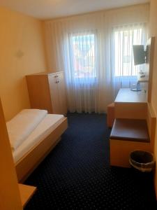 a small bedroom with two beds and a window at Hotel Rössle in Freiberg am Neckar