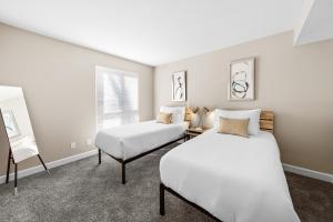 a bedroom with two beds and a chair at Kasa Downtown South Bend in South Bend