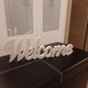 a sign that says welcome sitting on top of a table at Apartment Mansarda in Maribor