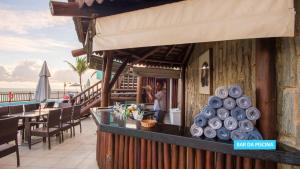 a restaurant with a counter with tables and chairs at Vila Galé Salvador in Salvador
