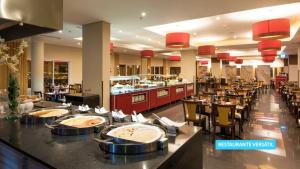 a restaurant with tables and chairs and a buffet at Vila Galé Salvador in Salvador