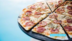 a pizza with pepperoni and olives on a plate at Vila Galé Salvador in Salvador