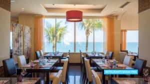 a restaurant with tables and chairs with a view of the ocean at Vila Galé Salvador in Salvador