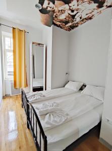 a bed in a room with a white bedspread at Hostel Franz Ferdinand in Sarajevo
