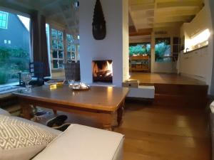 a living room with a table and a fireplace at Het Zeepaartje, knus en gezellig in Noordwijkerhout