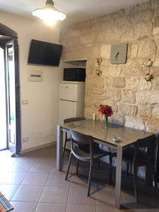 a kitchen with a table and a clock on the wall at La Casa sul Parco in Modica