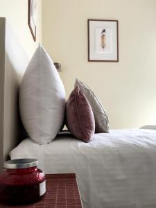 a bed with pillows and a jar on a table at Stergios_Apartments 05 in Kozani