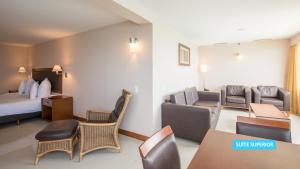 a hotel room with a bed and a living room at Vila Galé Salvador in Salvador