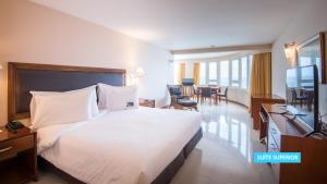 a hotel room with a bed and a television at Vila Galé Salvador in Salvador