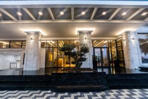 a building with a tree in the middle of it at Kraal Hotel Vlore in Vlorë