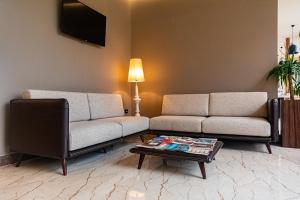 a living room with two couches and a coffee table at Kraal Hotel Vlore in Vlorë