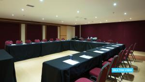 a conference room with long tables and red chairs at Vila Galé Salvador in Salvador