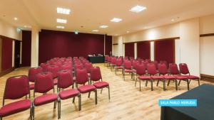 a conference room with red chairs and a stage at Vila Galé Salvador in Salvador
