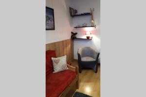 a living room with a red couch and a chair at Val Thorens 2 bedrooms 6 persons next slopes in Val Thorens