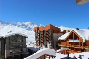 a ski lodge with snow covered mountains in the background at Val Thorens 2 bedrooms 6 persons next slopes in Val Thorens
