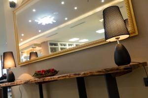 a mirror and a lamp on top of a table at Kraal Hotel Vlore in Vlorë