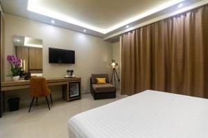 a hotel room with a bed and a desk and a chair at Kraal Hotel Vlore in Vlorë