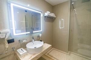 a bathroom with a sink and a shower at Kraal Hotel Vlore in Vlorë