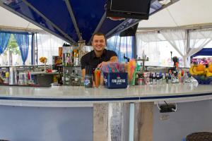 a man sitting at a bar with a counter with drinks at Palace Hotel in Sunny Beach