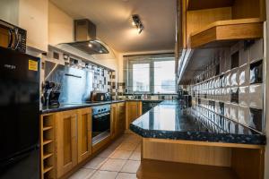 a large kitchen with a large counter top at Coppet Cove - 2 Bedroom Apartment - Saundersfoot in Saundersfoot