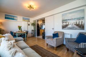a living room with a couch and chairs and a table at Coppet Cove - 2 Bedroom Apartment - Saundersfoot in Saundersfoot